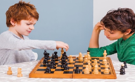 Two brothers are playing chess at home.