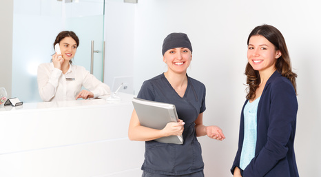 friendly woman behind reception desk administrator with Doctor and patient