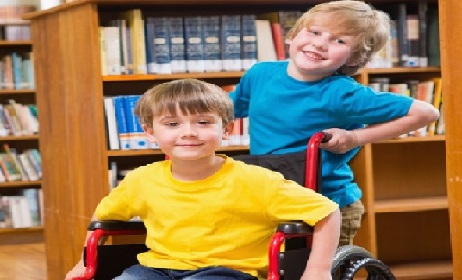 Cute pupils smiling at camera at the library