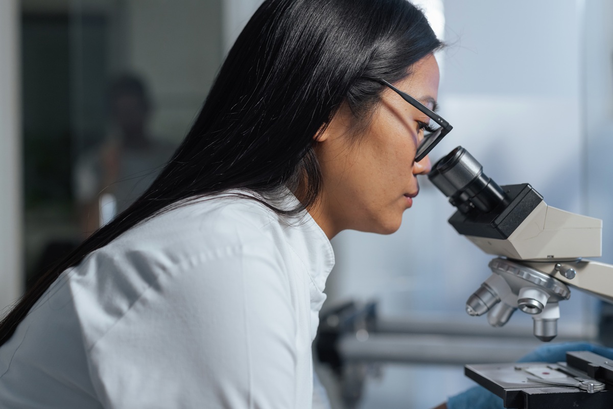Lab technician observing a blood sample under the microscope during the analysis