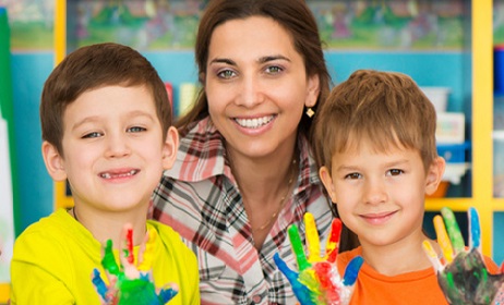Cute little children drawing with teacher at preschool class