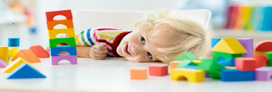 Kids toys. Child building tower of toy blocks.