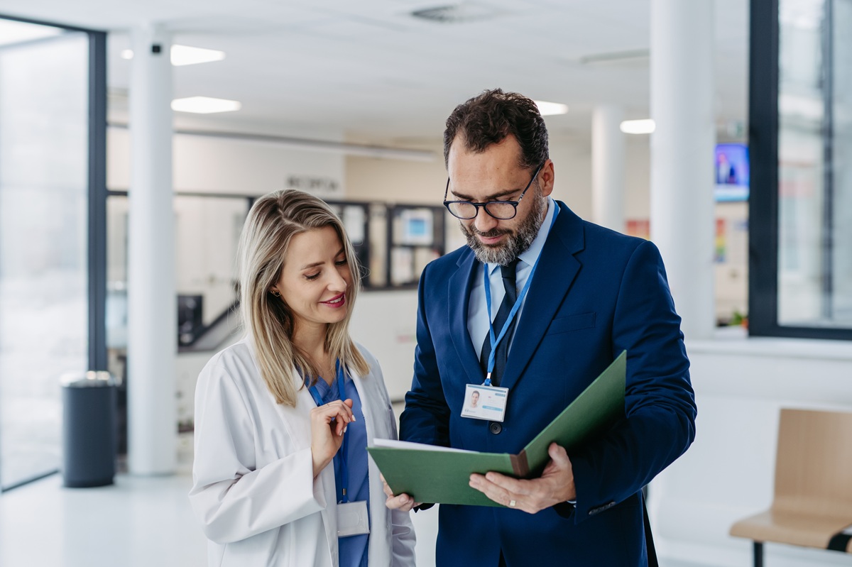 Pharmaceutical sales representative talking with doctor in medical building. Female doctor talking with hospital director, manager in private clinic.